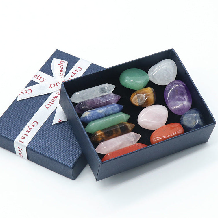 Set of colorful crystals in an open box with a branded ribbon on a white background